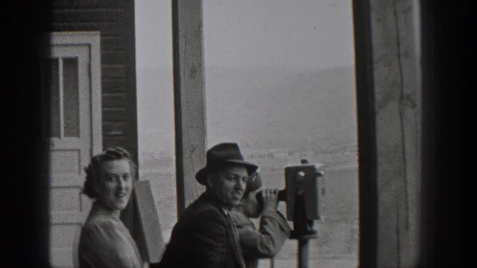 1938 Washington home-movie frame showing tourists beside coin-operated viewers at an outdoor overlook.