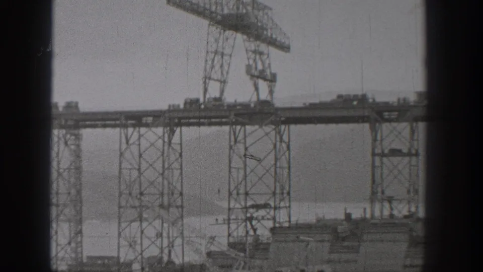 1938 Washington construction view with steel bridge framework, elevated deck, and crane structure seen in soft 8mm footage.