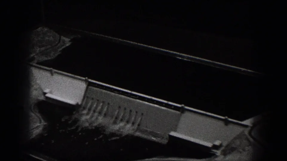 Washington 8mm frame showing a concrete spillway or dam structure beside dark water, viewed from an elevated position.