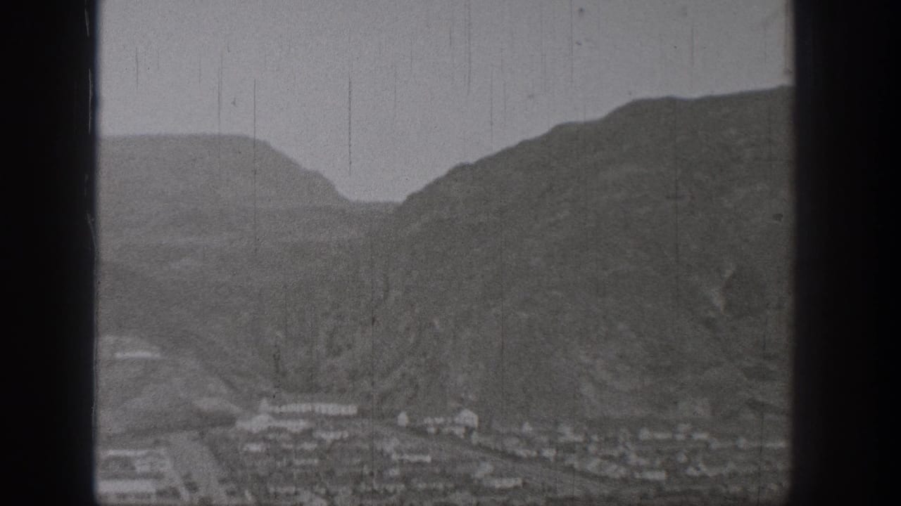 Mountain valley with a small town below steep hillsides.