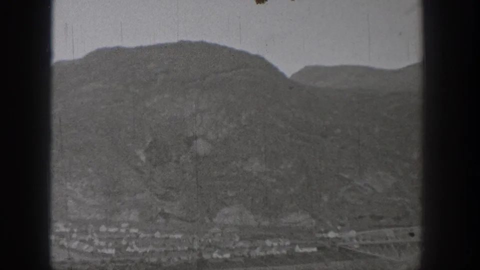 1938 Washington 8mm frame with hillside terrain and a faint town strip along the valley floor.