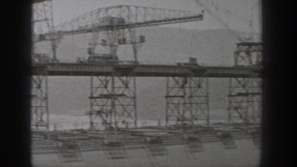 Washington 1938 8mm footage frame showing a large crane, steel support towers, construction decking, and distant hills.