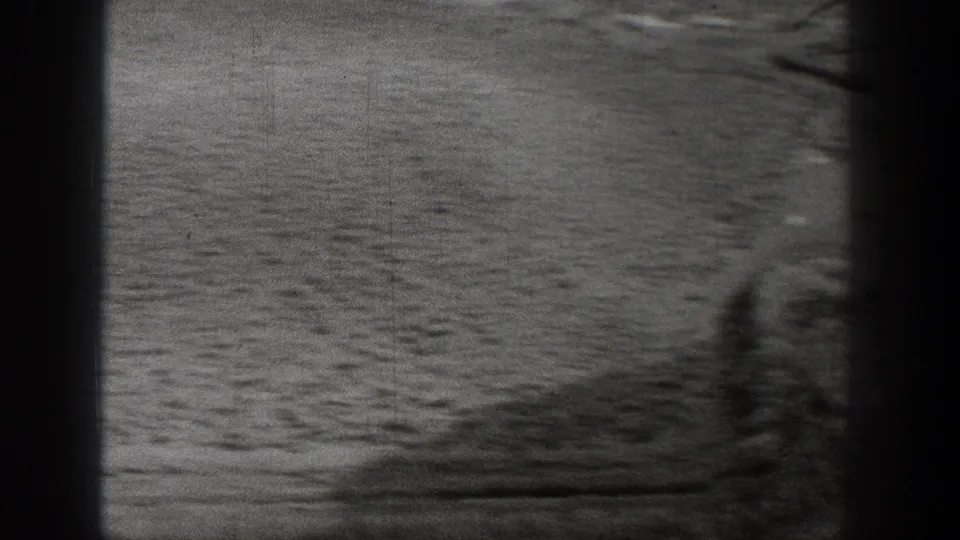 1938 Washington home-movie frame showing empty arid terrain, low vegetation, and soft panning blur at the frame edge.