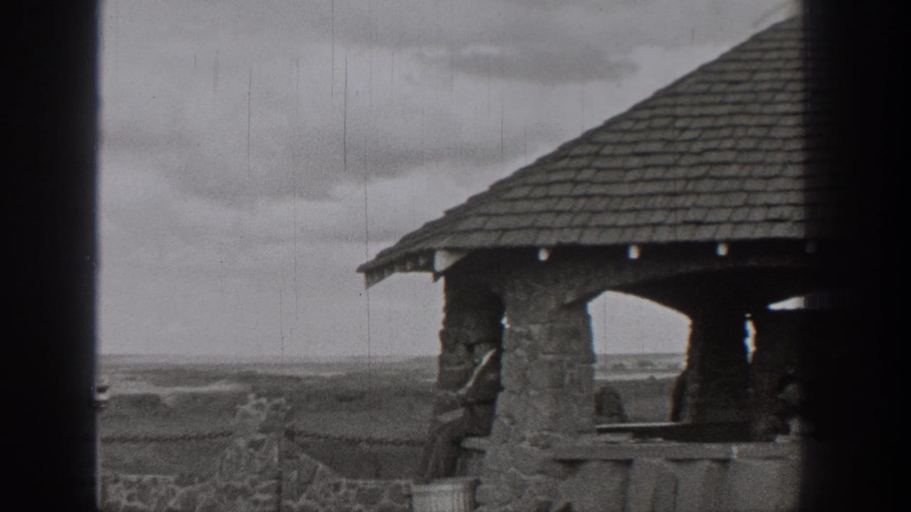 Stone gazebo edge and open landscape seen through a dark film gate.