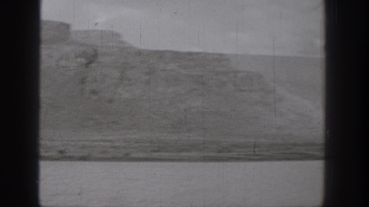 1938 Washington 8mm frame showing a broad waterway below rugged bluffs, with dark gate edges and visible film wear.