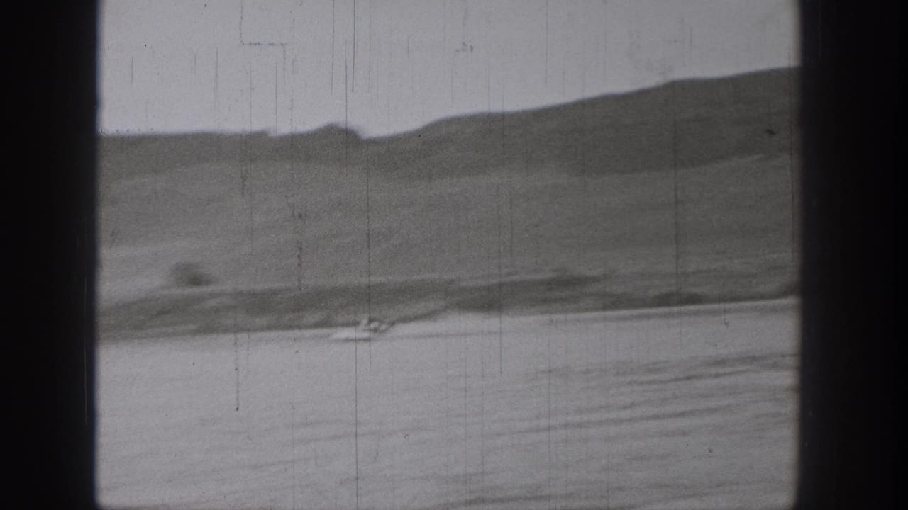 Final 1938 Washington frame with a tiny boat on calm water, distant hills, and visible 8mm wear.