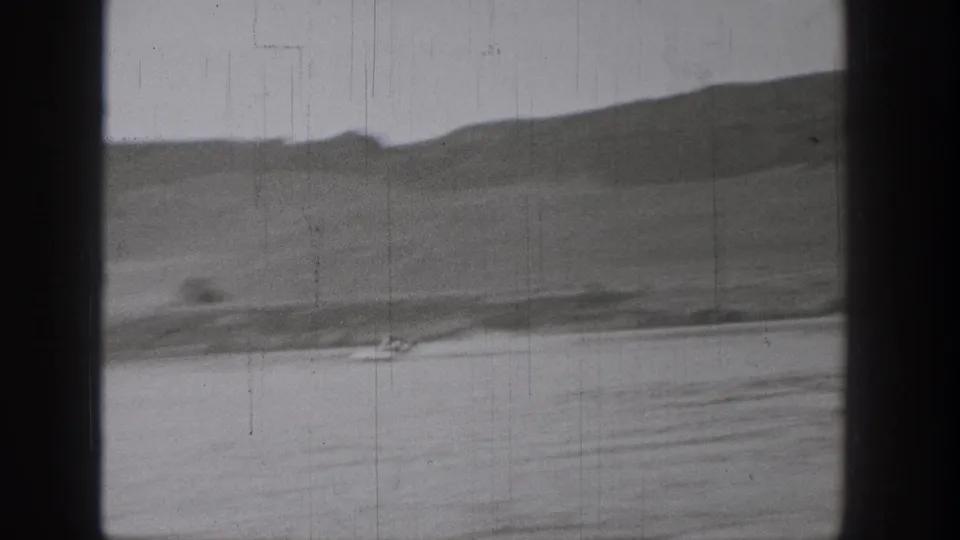 Final 1938 Washington frame with a tiny boat on calm water, distant hills, and visible 8mm wear.