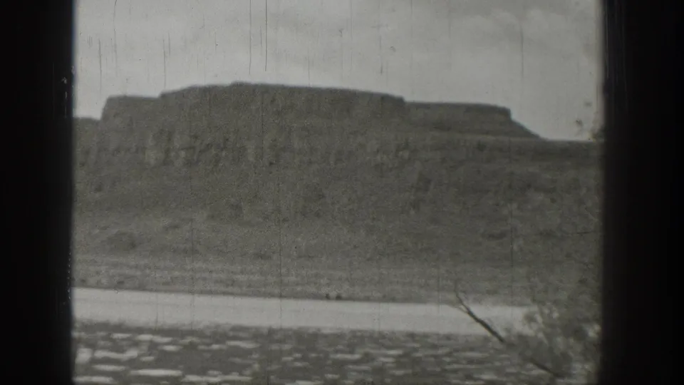 Rugged Washington lakeside cliffs fill the frame as rippled water crosses the foreground in soft 8mm footage.