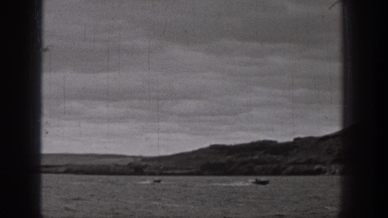 1938 Washington 8mm frame showing small boats on a lake or river with rolling hills and cloudy sky in the distance.