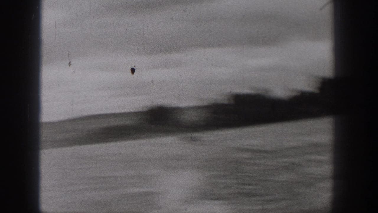 Blurred lake surface and shoreline seen through dark frame edges.
