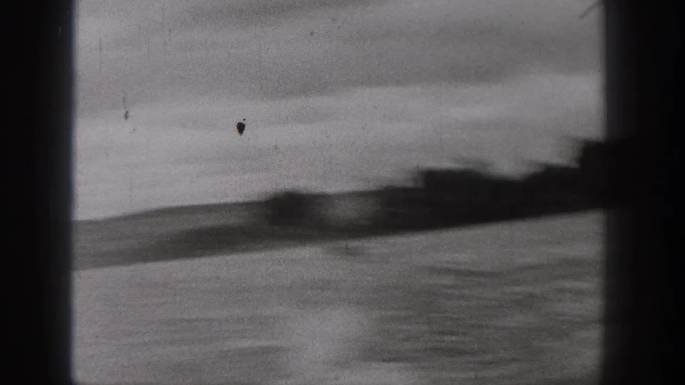 Soft, blurred 8mm view of lake water and a distant shoreline in Washington, with dark scan borders visible.