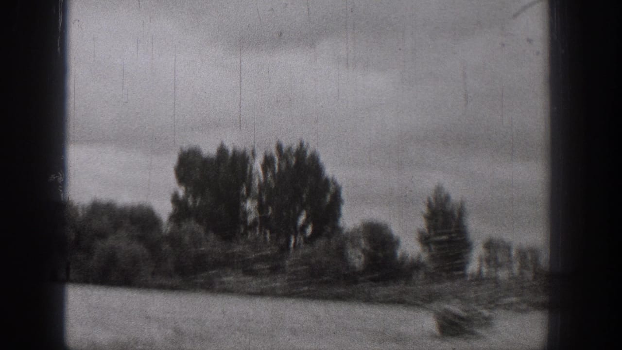 1938 Washington home-movie frame showing a small boat on rough river water, with distant trees and dark film borders.