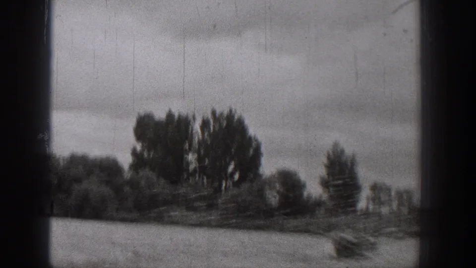 1938 Washington home-movie frame showing a small boat on rough river water, with distant trees and dark film borders.