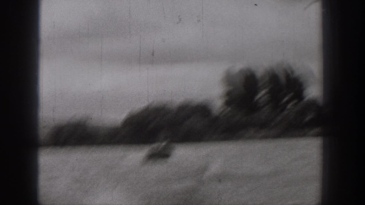 Motion-blurred 1938 Washington river frame with a small boat on choppy water and a dark wooded bank in the distance.