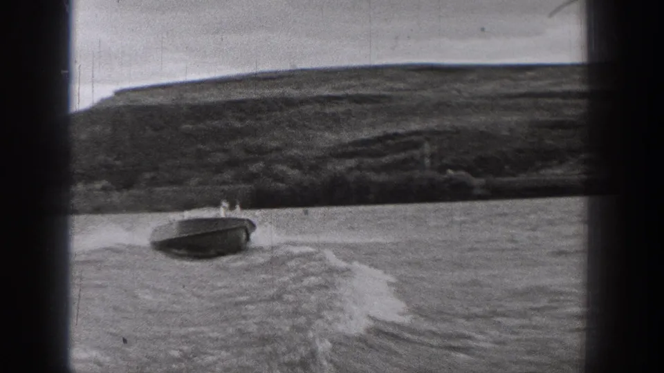 The motorboat passes near the lower frame of the 1938 Washington lake scene, with open water, wake, and a broad hillside shoreline behind.