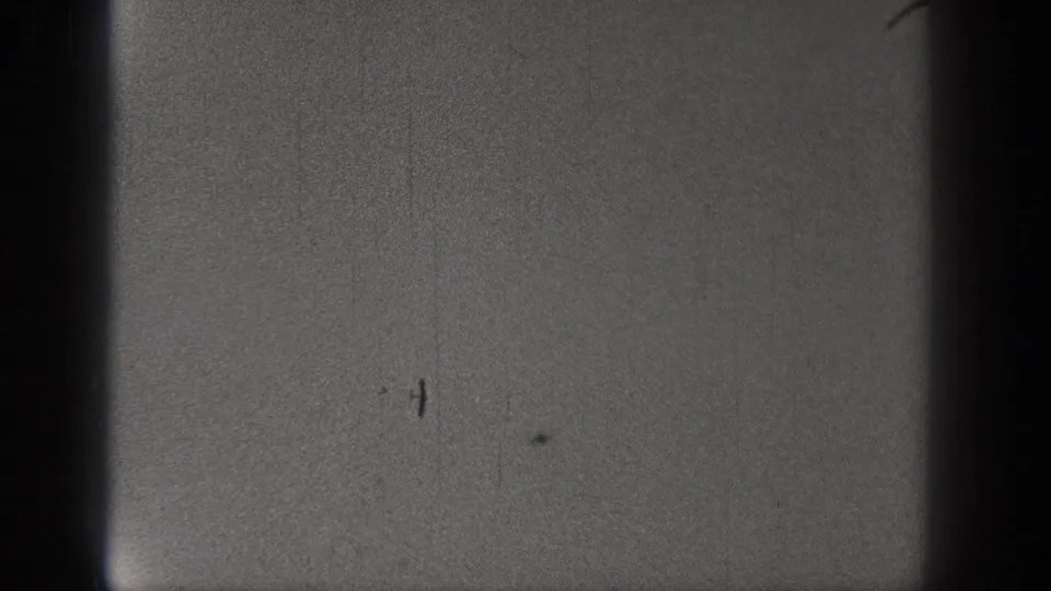 A 1938 Washington 8mm still with a dark vertical frame edge, gray exposure, grain, and scattered film marks.
