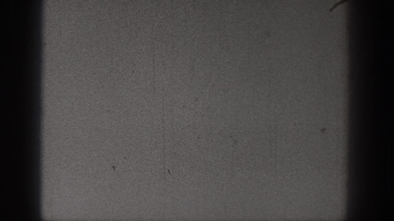 A dim 1938 Washington 8mm still with grain, faint scratches, and no clearly identifiable subject in the visible frame.