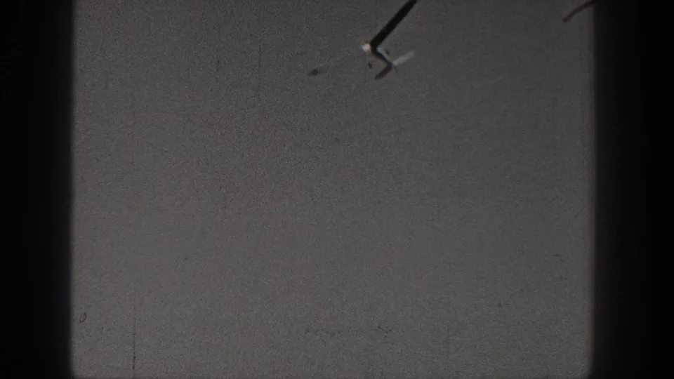 Distant small airplane in a Washington 1938 8mm home-movie sky shot with heavy grain and dark borders.