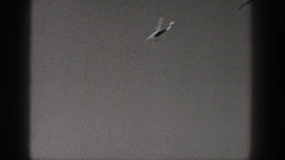 Small aircraft appears near the upper right in grainy 8mm footage from the supplied Washington 1938 clip.