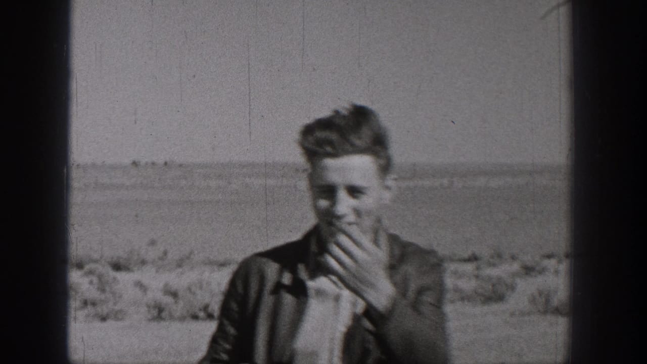 A young person appears in the final Washington 8mm frame, standing before open ground and distant low horizon.