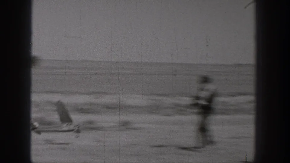 1938 Washington home-movie frame showing a small model airplane and a blurred standing figure in an open outdoor area.