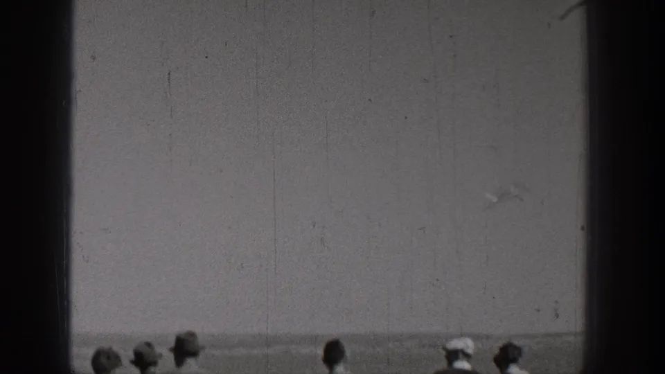 1938 Washington frame with distant onlookers along the bottom edge as the camera looks across a flat outdoor scene.
