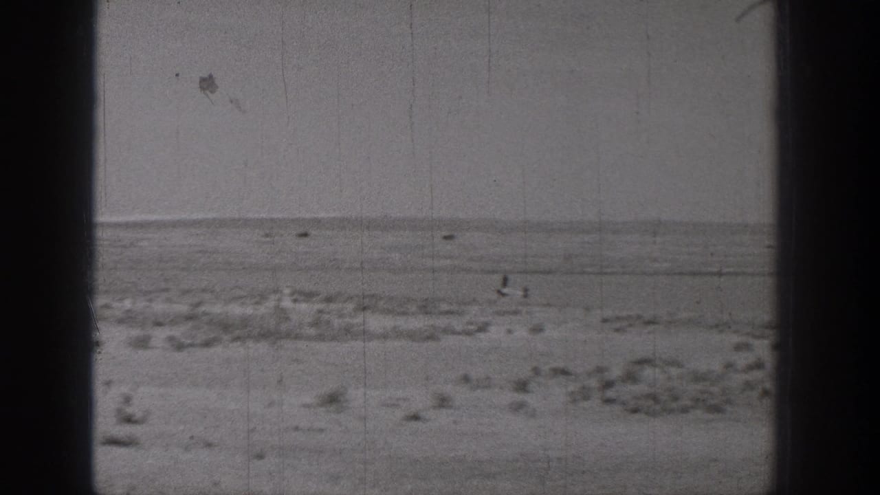 1938 Washington 8mm frame showing a flat, sandy open landscape with low scrub and a distant horizon.