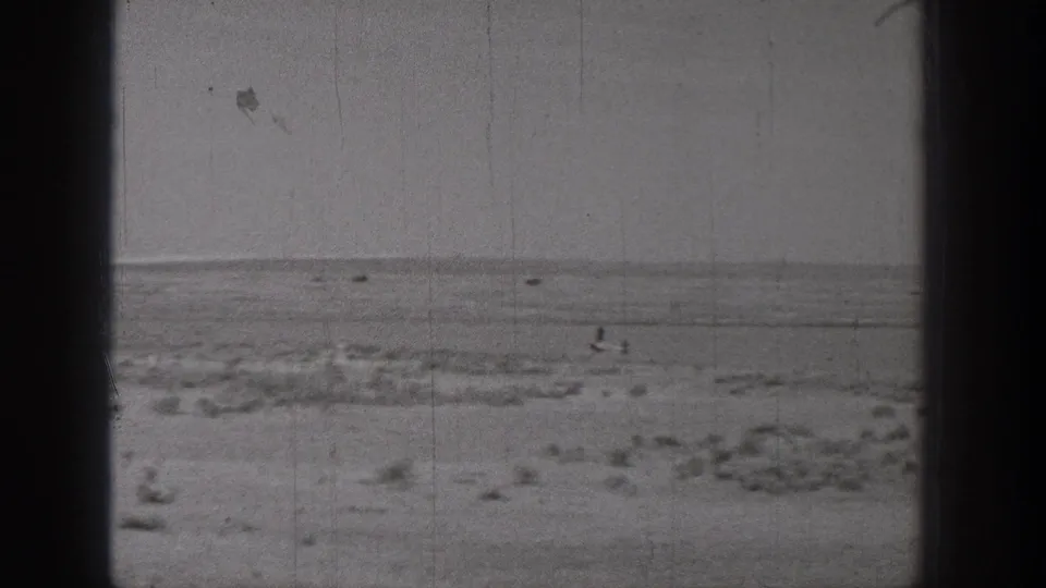 1938 Washington 8mm frame showing a flat, sandy open landscape with low scrub and a distant horizon.