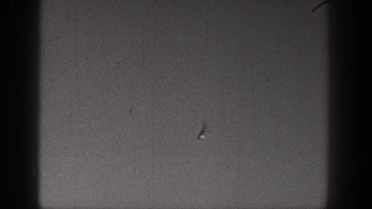 1938 Washington 8mm frame with sparse sky or ground tone and a small dark object near the lower portion.
