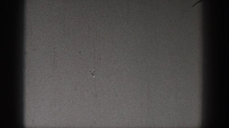 1938 Washington 8mm frame showing a dark, grainy sky area with film gate shadowing and small surface marks.