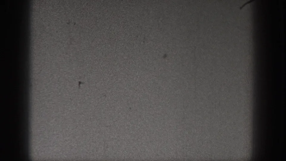 1938 Washington 8mm frame showing dark sky texture, small surface marks, and pronounced gate shadow along the frame edge.