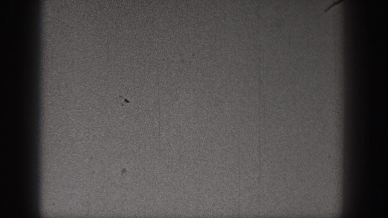 1938 Washington 8mm frame with a small bird-like speck low in the dark, grainy sky and visible film wear.