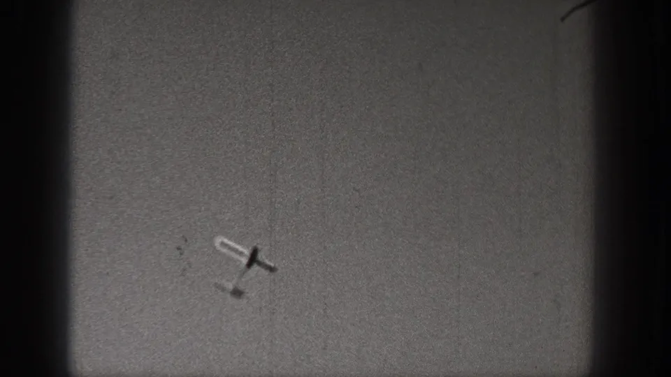A small aircraft appears tilted in flight within a dark-bordered 1938 Washington 8mm home-movie frame.