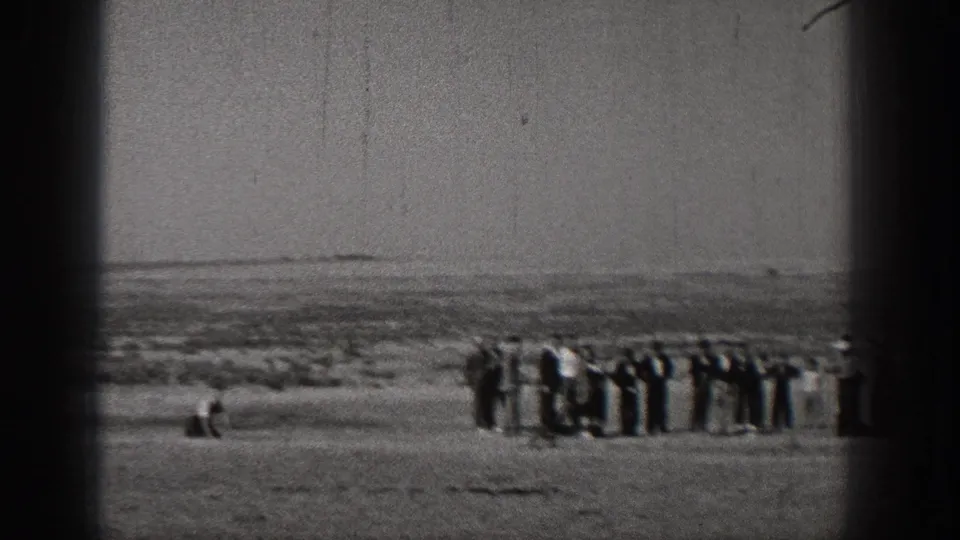 A group of distant onlookers stands in a line in the Washington landscape as a small aircraft activity unfolds nearby.
