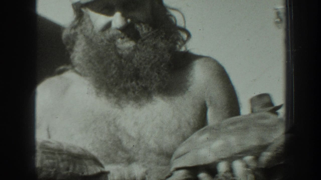 In 1939 California home-movie footage, a bearded man wearing a cap holds a tortoise while facing the camera.