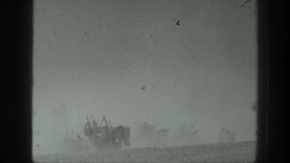 Distant military vehicles and personnel are partly obscured by dust in a 1939 California field scene.