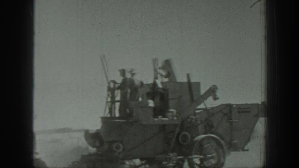 California 1939 home-movie frame showing several workers on a large grader-like construction machine in open ground.