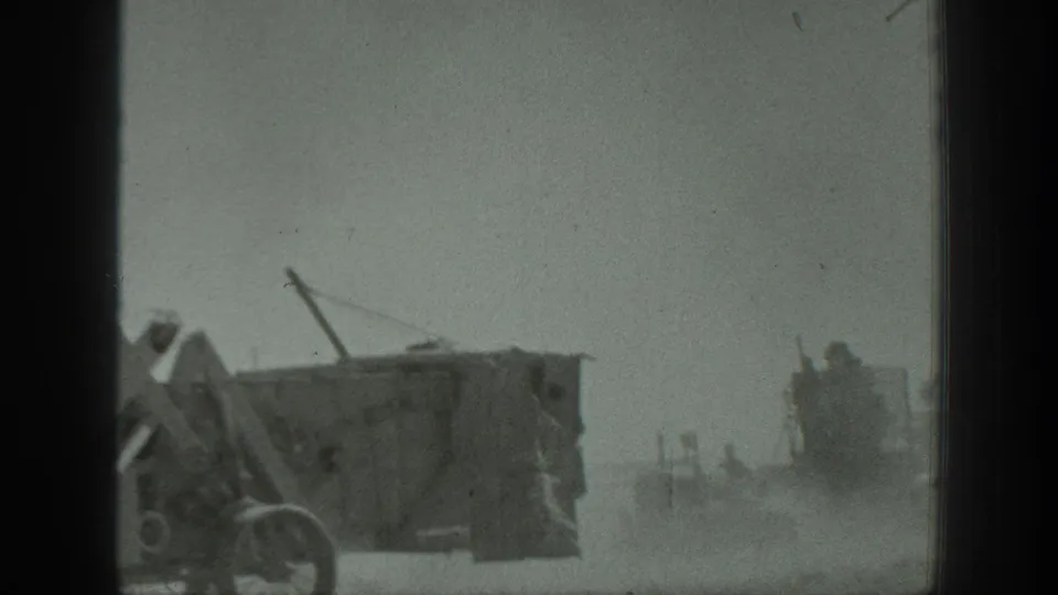 1939 California frame with a large machine in the foreground and another work vehicle partly obscured by dust behind it.
