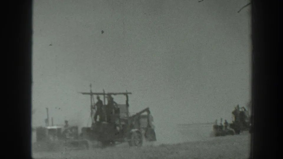 Dusty field machinery in California, dated by metadata to 1939, passes through the lower frame with another implement visible farther away.