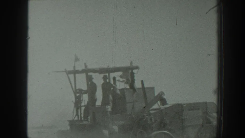 The frame shows men riding an open agricultural implement behind a tractor in a dusty California field, based on supplied 1939 metadata.