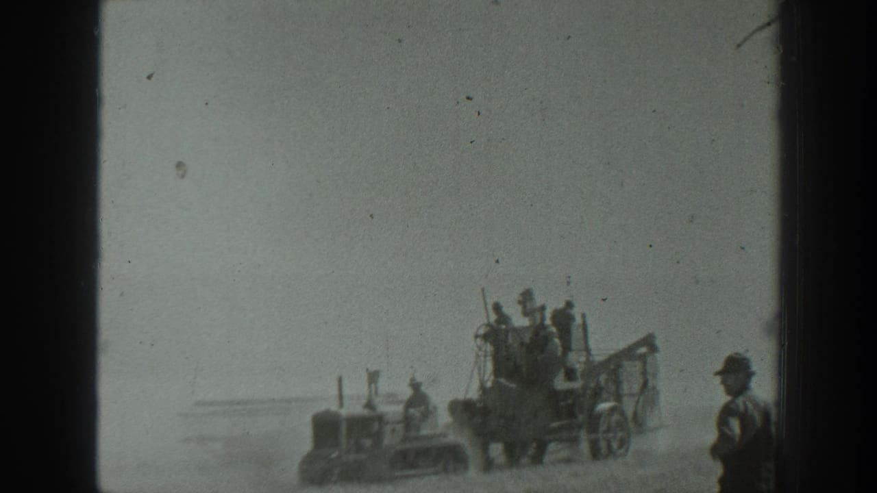 1939 California 8mm frame showing uniformed personnel gathered near a tractor-like vehicle and artillery equipment on dusty open ground.
