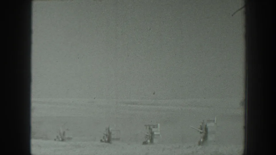 Soft 8mm California frame from 1939 with a snow-covered landscape, distant unclear figures or structures, and dark film-frame edges.