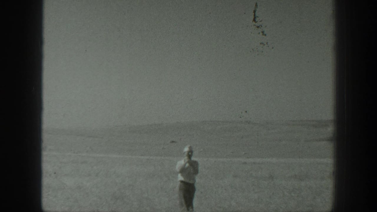 A man in a field appears small within a soft black-and-white 1939 California home-movie frame.