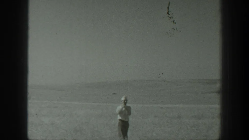 A man in a field appears small within a soft black-and-white 1939 California home-movie frame.