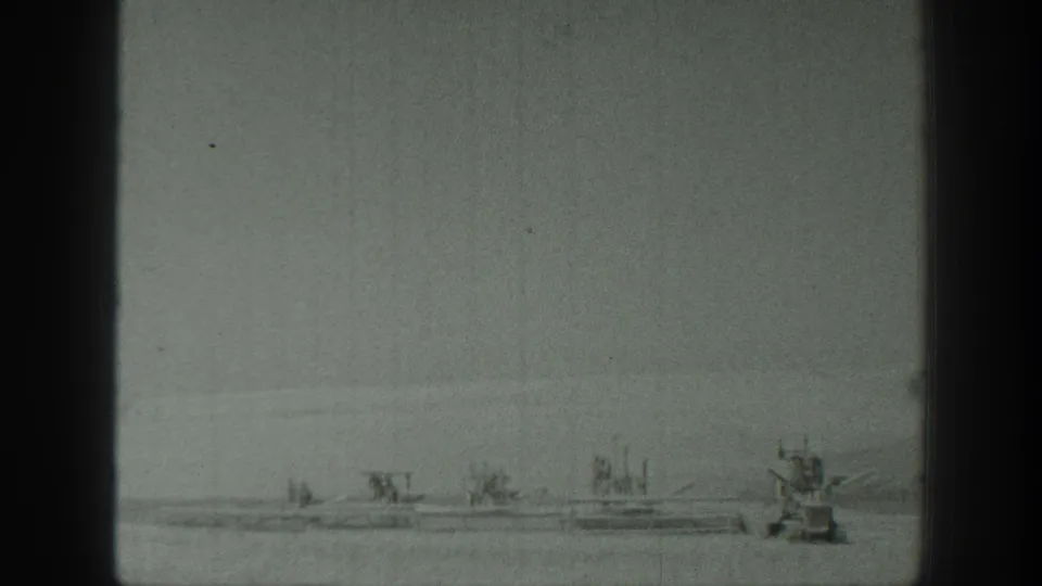 1939 California home-movie frame with several small boats and a larger motorboat-like craft on still water.