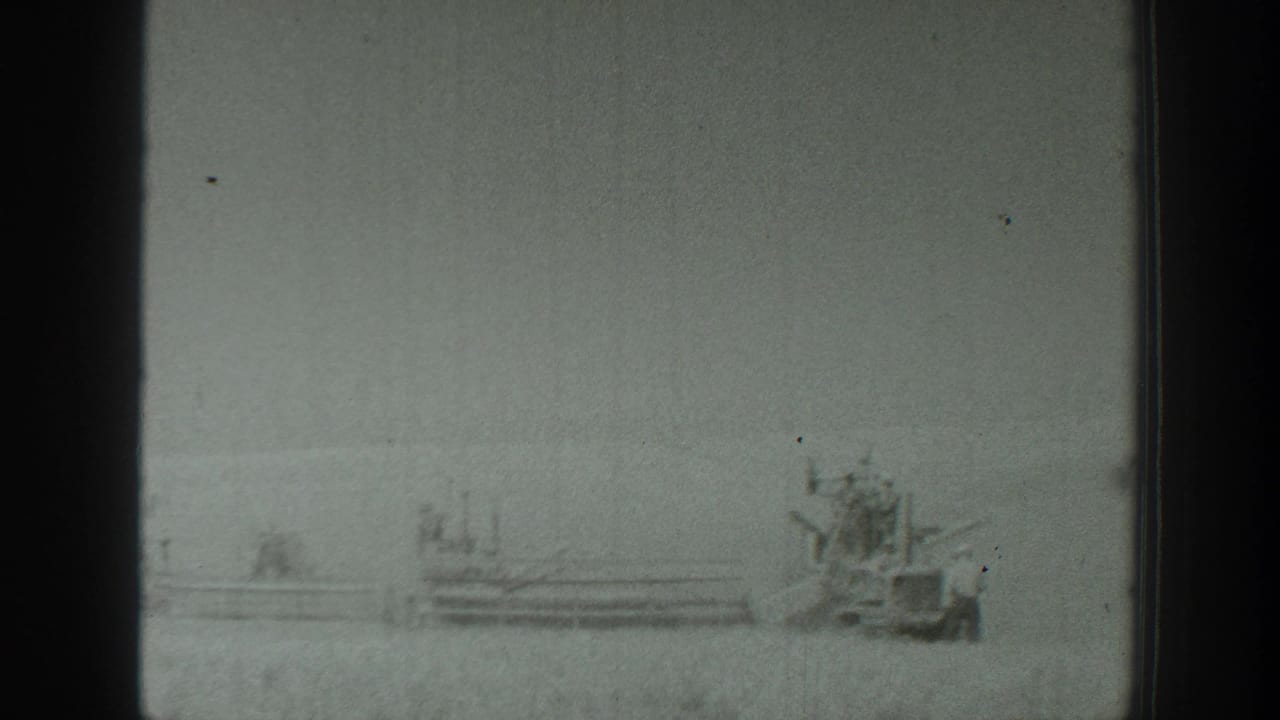 1939 California 8mm frame showing a distant military-style vehicle and small figure across an open rural field.