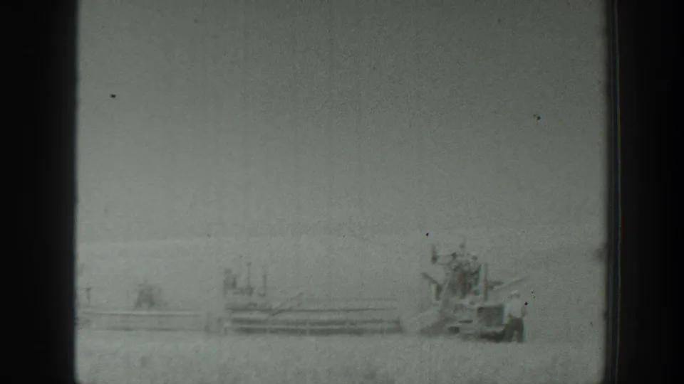 1939 California 8mm frame showing a distant military-style vehicle and small figure across an open rural field.