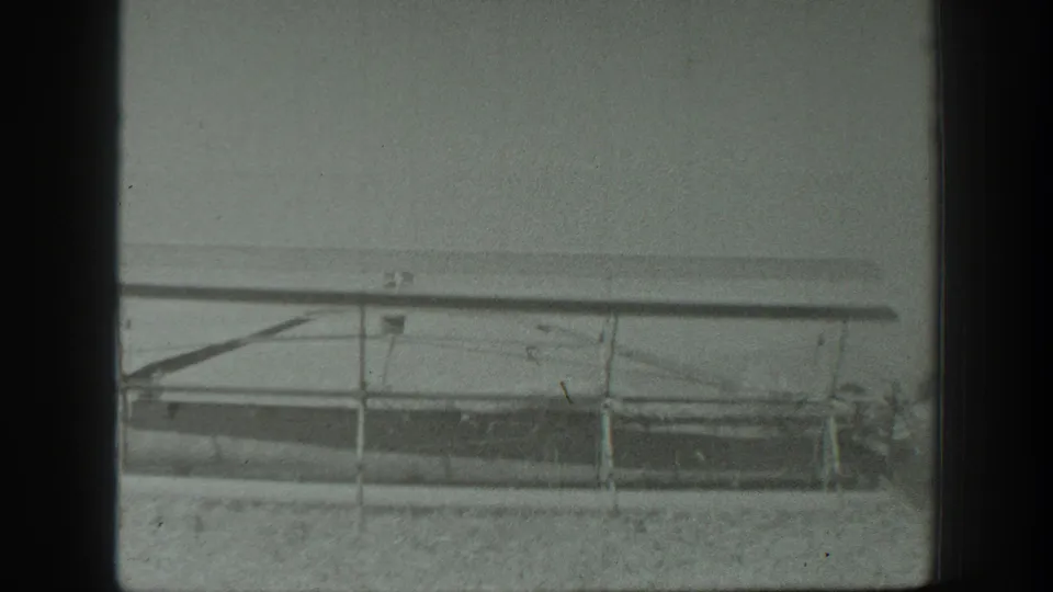 The 8mm frame shows the side of a long agricultural cutter or attachment in the 1939 California farm scene.