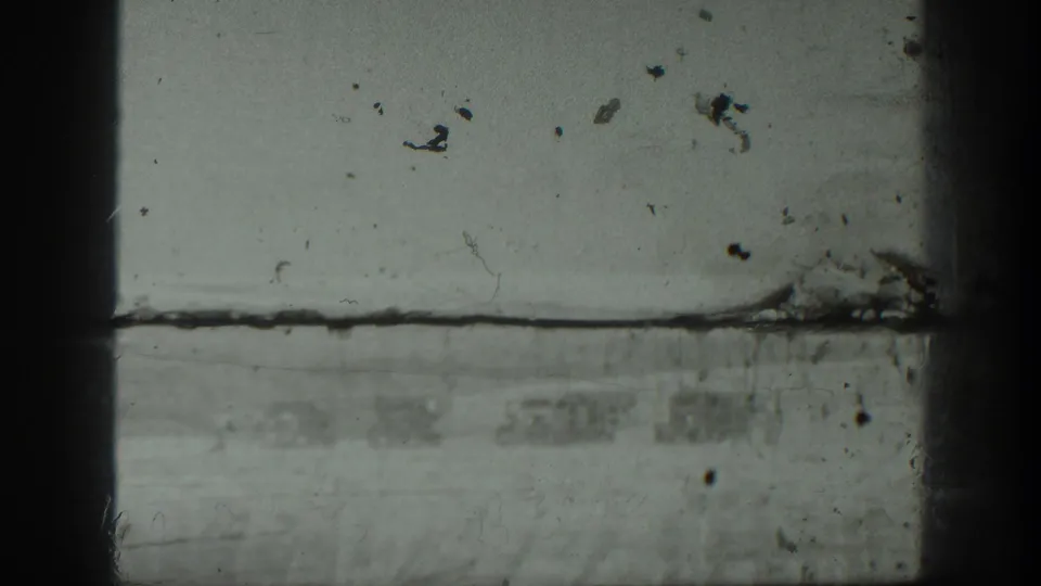 Black-and-white 8mm frame with visible film wear and a partly obscured outdoor scene from the 1939 California home movie.