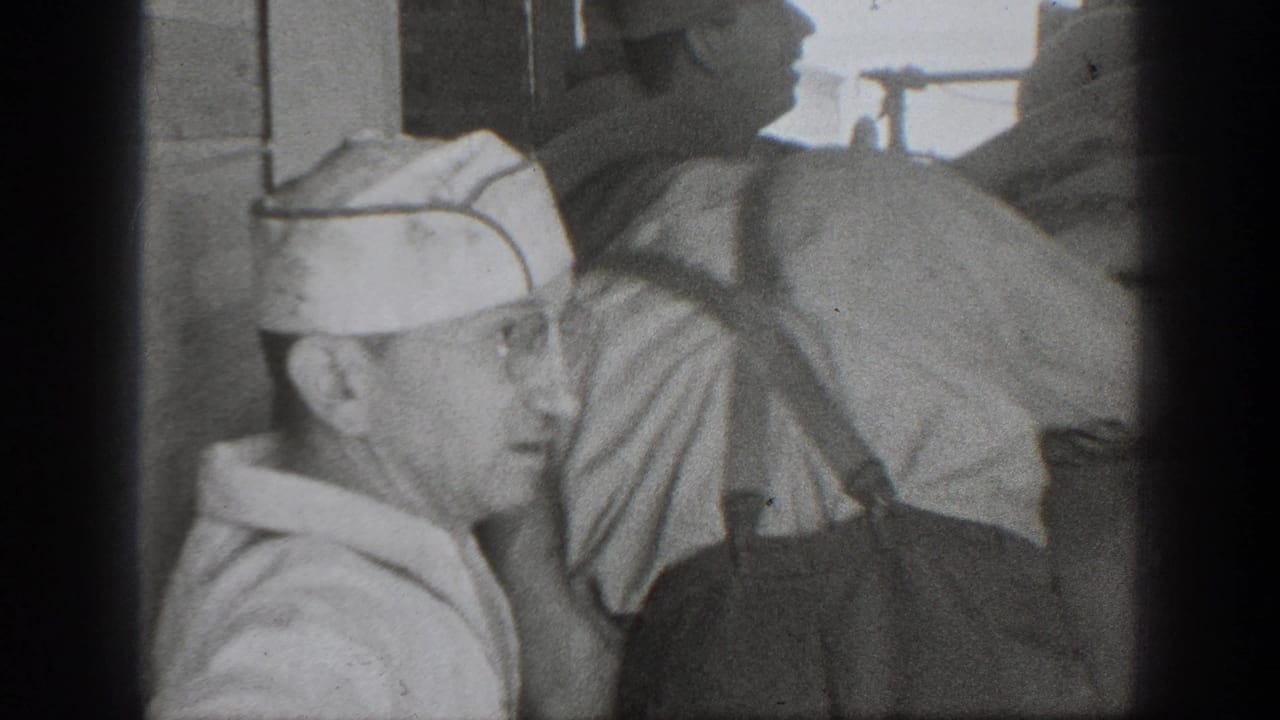 1939 California 8mm frame showing adult men in caps and workwear gathered around large sacks in a dim labor setting.